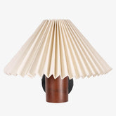 White pleated shade wall lamp with a natural wooden cylindrical base in walnut finish, perfect as a bedside wall lamp or decorative wall sconce for minimalist and vintage interiors.